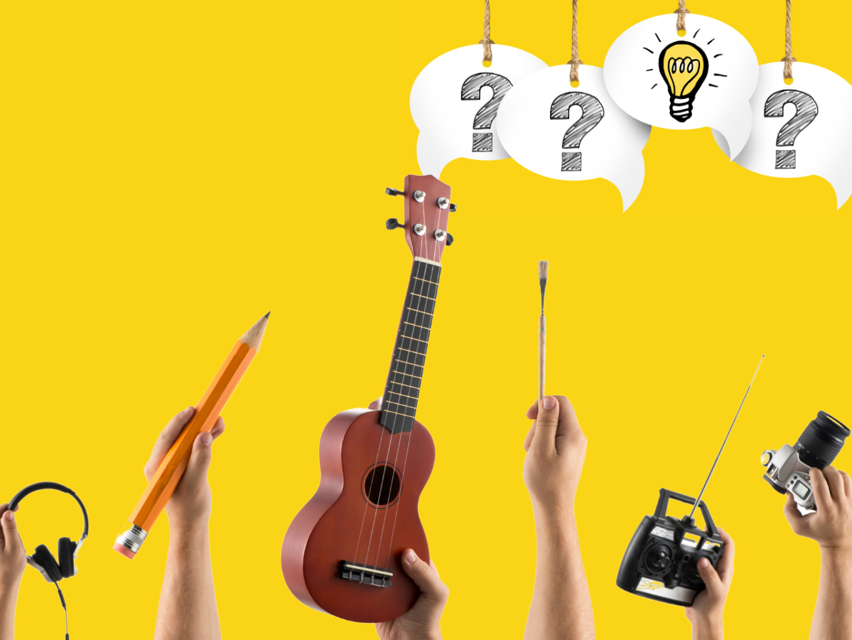 hands holding headphones, a pencil, a ukulele, and a remote control in front of a yellow background