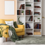 a yellow armchair in front of a large white bookcase full of books