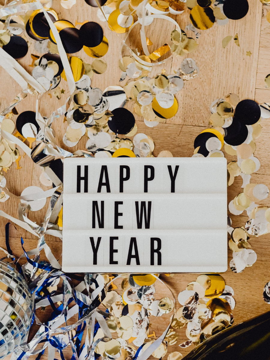 Sign reading "Happy New Year" with confetti and streamers