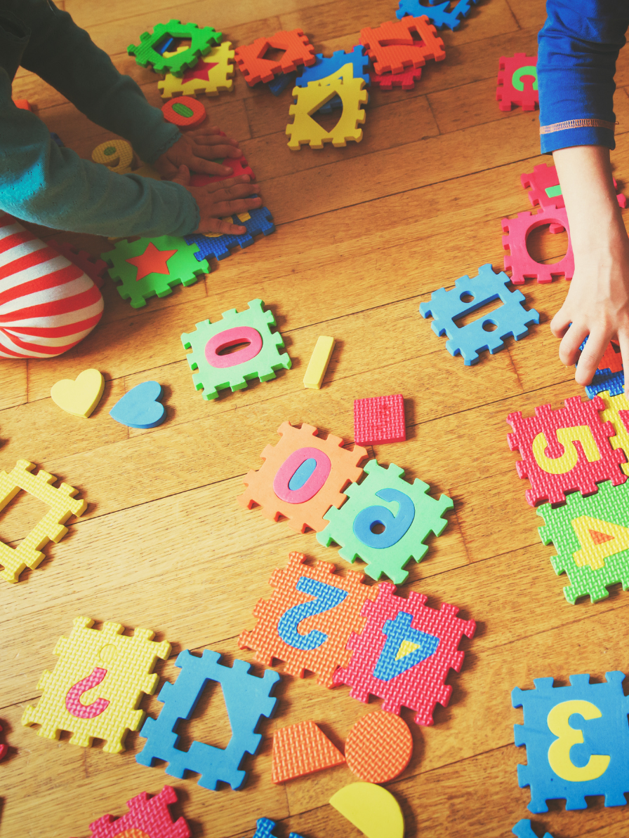 Kids play together using toys which encourage color, number, and shape recognition.