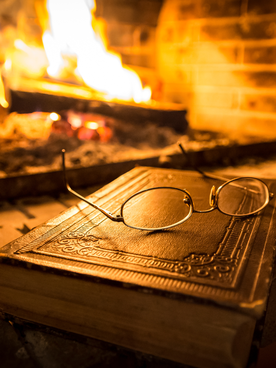 Glasses on a book in front of a fireplace