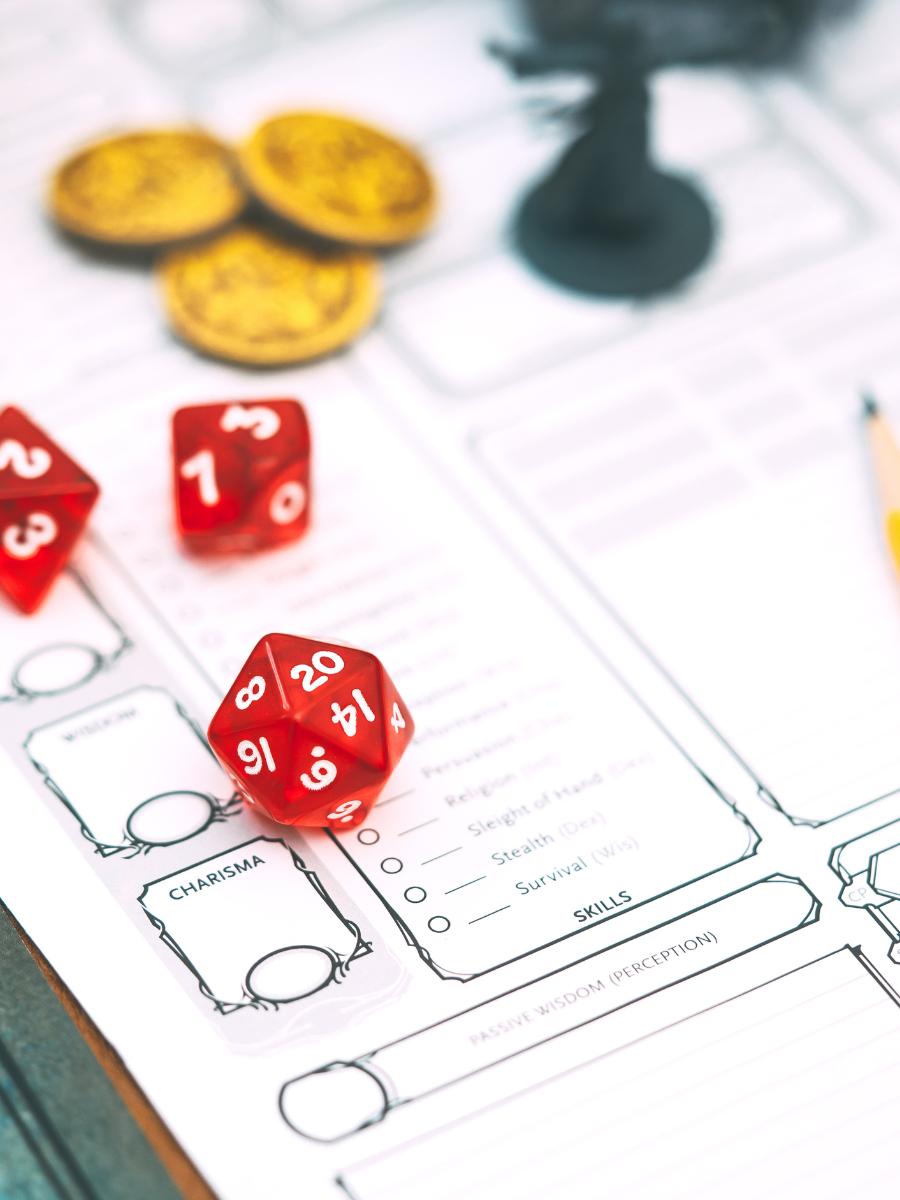 dungeons and dragons character sheet and dice with gold coins in the background
