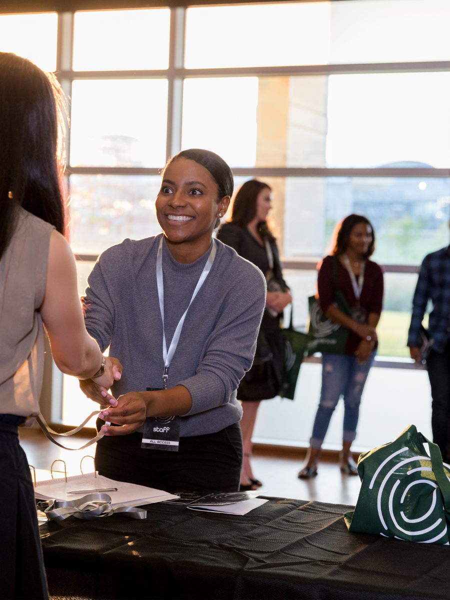 women shaking hands at conference table