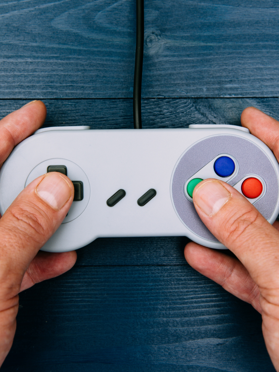 hands holding an old nintendo controller