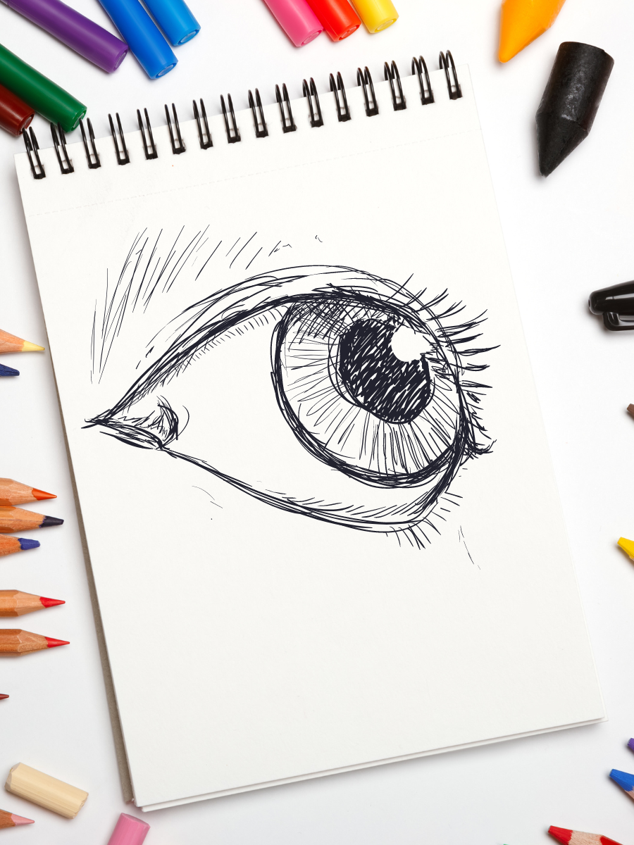 sketch paper with an eye drawn on it, surrounded by pens, markers, and pencils of varying colors