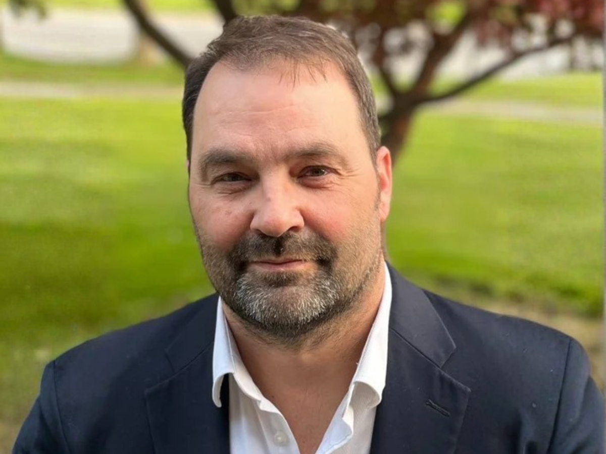 author Michael Parzymeiso looking directly at the camera, standing in front of a tree
