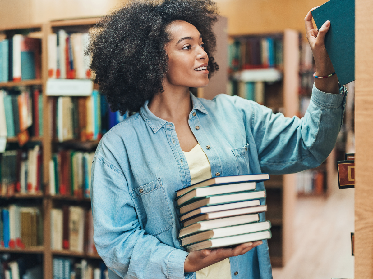 woman shelving books with stacks behind her