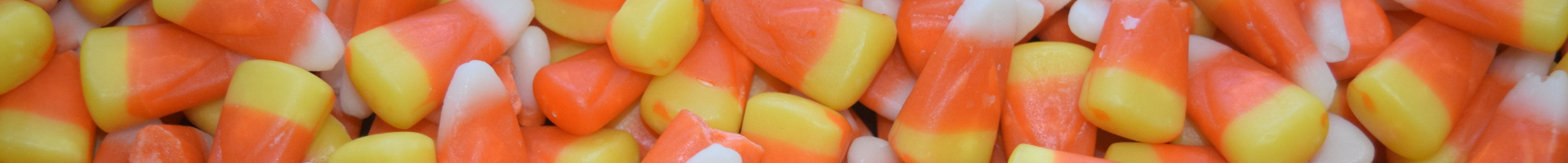 Close up of a pile of yellow, orange, white striped candy corn